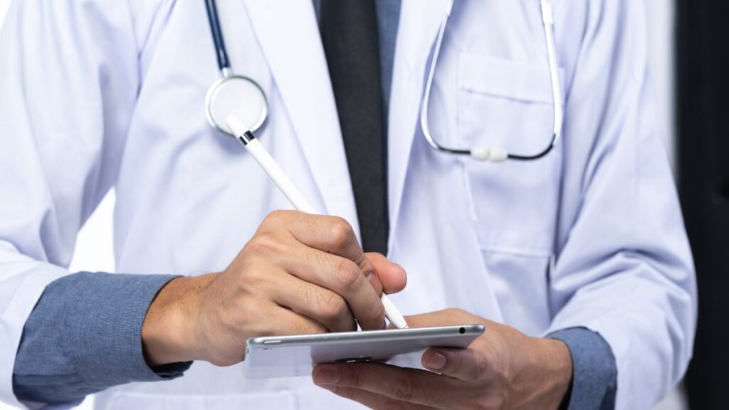 A doctor prepares a medication-assisted treatment order on a pad.